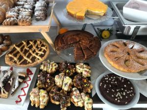 una mesa llena de diferentes tipos de pasteles y pasteles en Hotel Kim en Rímini