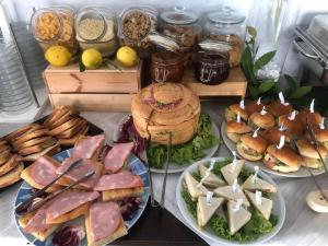 uma mesa com pratos de sanduíches e outros alimentos em Hotel Kim em Rimini