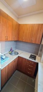 uma pequena cozinha com armários de madeira e um lavatório em Rio apartments em Banja Luka