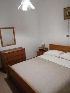 a bedroom with a bed and a dresser and a mirror at I Trecento in Padula