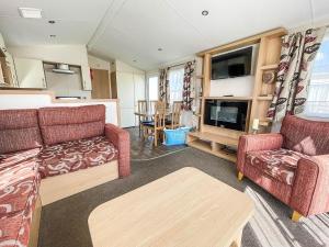 a living room with two couches and a tv at Lovely Caravan With Decking At Sand Le Mere Park In Yorkshire Ref 71032tv in Tunstall
