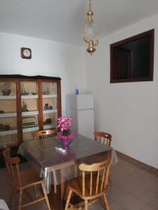 a dining room with a table with chairs and a television at I Trecento in Padula