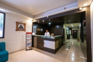 a man standing at a bar in a hotel lobby at Hotel Rama Heritage in Nashik