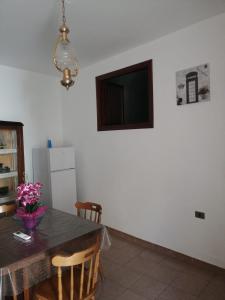 a kitchen with a table and a television on a wall at I Trecento in Padula
