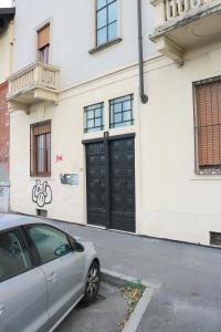 um carro estacionado em frente a um edifício com uma garagem preta em Lovely Navigli Studio with balcony - Via Carlo torre em Milão