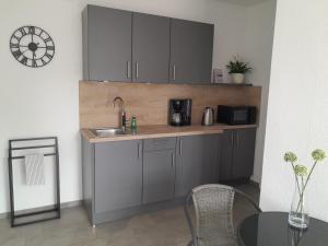 a kitchen with gray cabinets and a sink and a table at Ferienwohnung Wussegel in Hitzacker