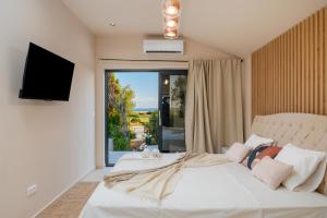 a bedroom with a large white bed with a large window at Villa Slatina near Zrce beach in Novalja +49 photos