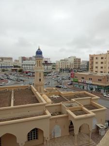 a building with a clock tower in the middle of a city at Argaan Apartment in Salalah