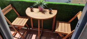 una mesa de madera con 2 sillas y una planta en ella en Suite House 5 Terre, en La Spezia
