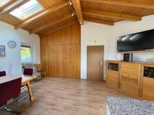 uma sala de estar com uma mesa e uma televisão na parede em Oyer Ferienhaus em Oy-Mittelberg