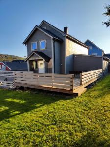 a house with a wooden fence in front of it at Apartament 2 in Havøysund +7 photos