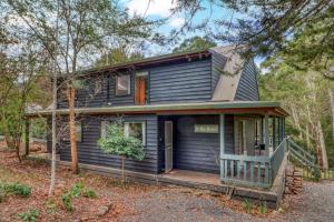 een blauw huis met een veranda in het bos bij The Bower in Merrijig