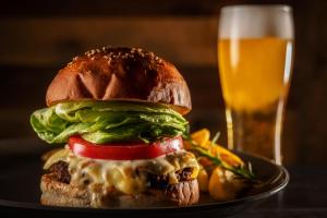 a sandwich on a plate with a glass of beer at HOTEL MYSTAYS Okayama in Okayama