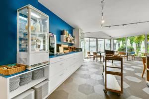 uma cozinha com armários brancos e uma parede azul em Logis Hôtel & Restaurant Ludik em Bergerac