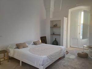 a white bedroom with a large white bed in it at L’Edicola Votiva in Casarano