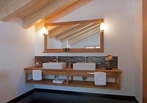 a bathroom with two sinks and a mirror at Hotel Waldhaus in Bettmeralp