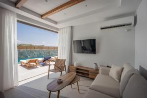 uma sala de estar com um sofá e uma grande janela em Stefi Villas - Deluxe Pool Bliss Retreats em Anópolis