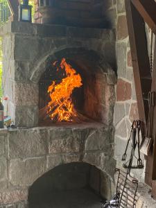 a brick oven with a fire in it at Cabana Miska Chalet in Miercurea-Ciuc