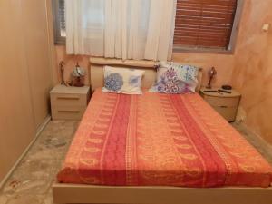 um quarto com uma cama com um edredão e almofadas laranja em Nice Fabron 90 m2 avec Garage em Nice