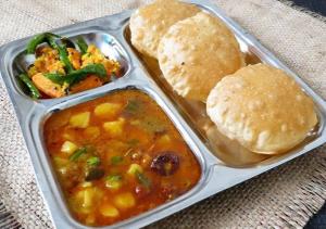 a plastic container filled with food with patties and biscuits at Baga View Inn in Baga