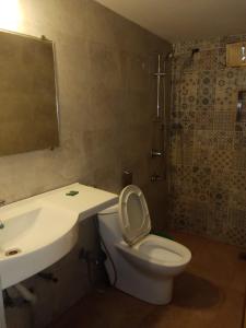 a bathroom with a white toilet and a sink at Sea Breeze Inn, Calangute Goa in Calangute