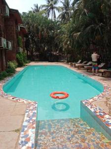 a swimming pool with a red frisbee in it at Sea Breeze Inn, Calangute Goa in Calangute