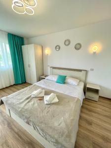 a bedroom with a large bed with two towels on it at Vila Cochilia Costinesti ULTRACENTRAL 3 stele in Costinesti