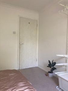 a room with a bed and a door and a plant at Croxley Room with free Parking in Croxley Green