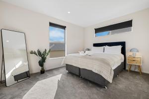 a bedroom with a large bed and a large mirror at Addington Delight - Christchurch Holiday Home in Christchurch