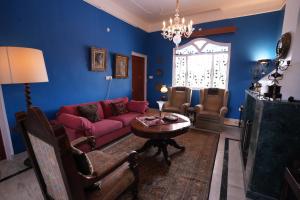 a living room with a purple couch and a table at lalita homestay countryside in Khajurāho