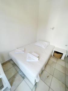 a white bed with two pillows on it in a room at Hotel Anezina in Drios