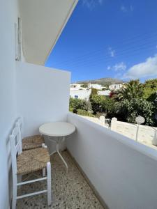 a white balcony with a table and a chair at Hotel Anezina in Drios