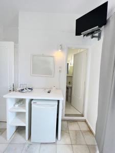 a white desk in a white room with a mirror at Hotel Anezina in Drios