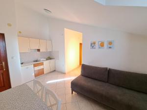 a living room with a couch and a kitchen at apartman Sanja-centar in Sveti Filip i Jakov