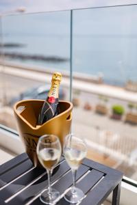 eine Flasche Champagner und zwei Gläser auf dem Tisch in der Unterkunft Naxos Marina Bay in Giardini-Naxos
