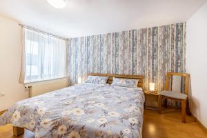 1 dormitorio con 1 cama y papel pintado con motivos florales en Alb Rose Ferienwohnung, en Sonnenbühl