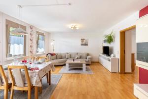 ein Wohnzimmer mit einem Tisch und einem Sofa in der Unterkunft Alb Rose Ferienwohnung in Sonnenbühl