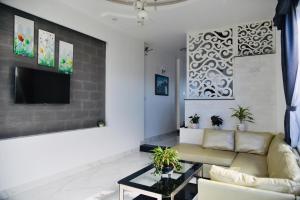 sala de estar con sofá y TV en Thu Linh Villa, en Da Lat