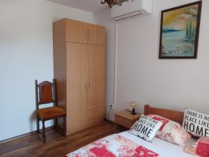 a bedroom with a bed and a cabinet and a chair at Studio Apartment Nikola in Janjina