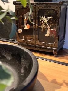 Un jarrón con una pintura al lado de una tele. en Casa Clementine - Boutique Guesthouse, en Veldhoven