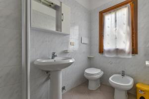 a white bathroom with a sink and a toilet at Casa Castagnola in Marciana