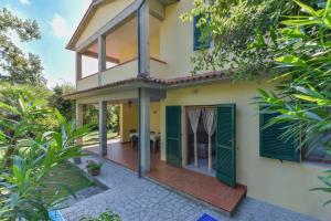 a house with green shutters and a patio at Casa Castagnola in Marciana