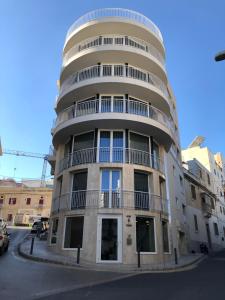 een hoog gebouw met een ronde top bij Village Point Apartments in Sliema