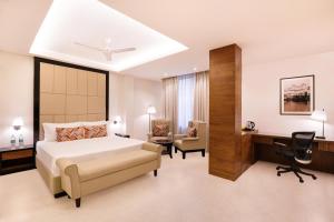 a bedroom with a bed and a desk and a chair at Lemon Tree Hotel Bhopal in Bhopal