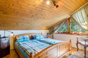a bed in a room with a wooden ceiling at Rose Garden in Heiligenberg