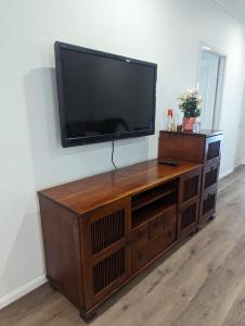 a entertainment center with a flat screen tv on a wall at Immaculate 2-Beds Entire House Chermside Brisbane in Brisbane