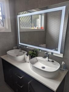 baño con 2 lavabos y espejo grande en Immaculate 2-Beds Entire House Chermside Brisbane, en Brisbane