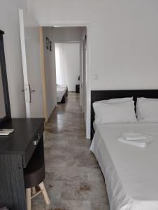 Habitación de hotel con 2 camas y escritorio en Katerina Apartments en Kalamata