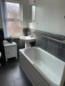 a bathroom with a bath tub and a sink at Marks Place in Liverpool