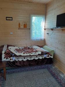 - une chambre avec un lit dans une pièce en bois dans l'établissement Riveside, à Martvili